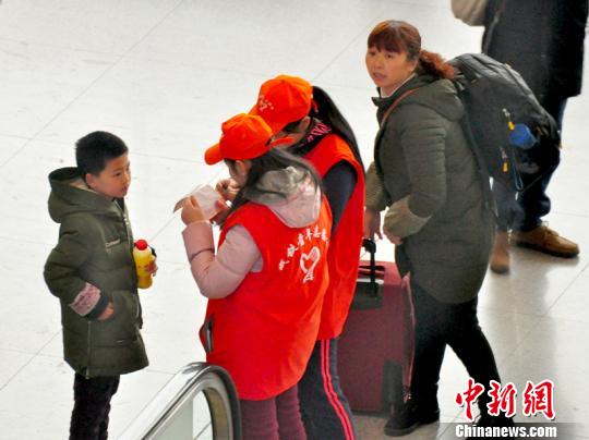 鐵路青年志愿者為攜帶兒童出行的旅客提供咨詢解答?！钦鳌z